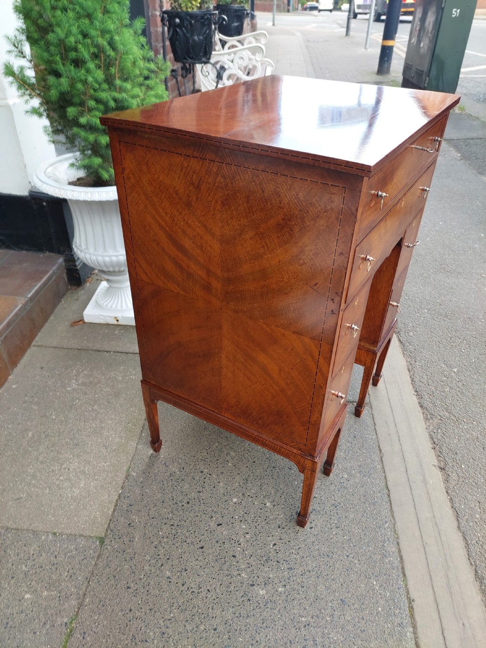 A late 19th-century George II style mahogany kneehole desk featuring herringbone inlay, brass drop handles, and a central recessed cupboard. View VI