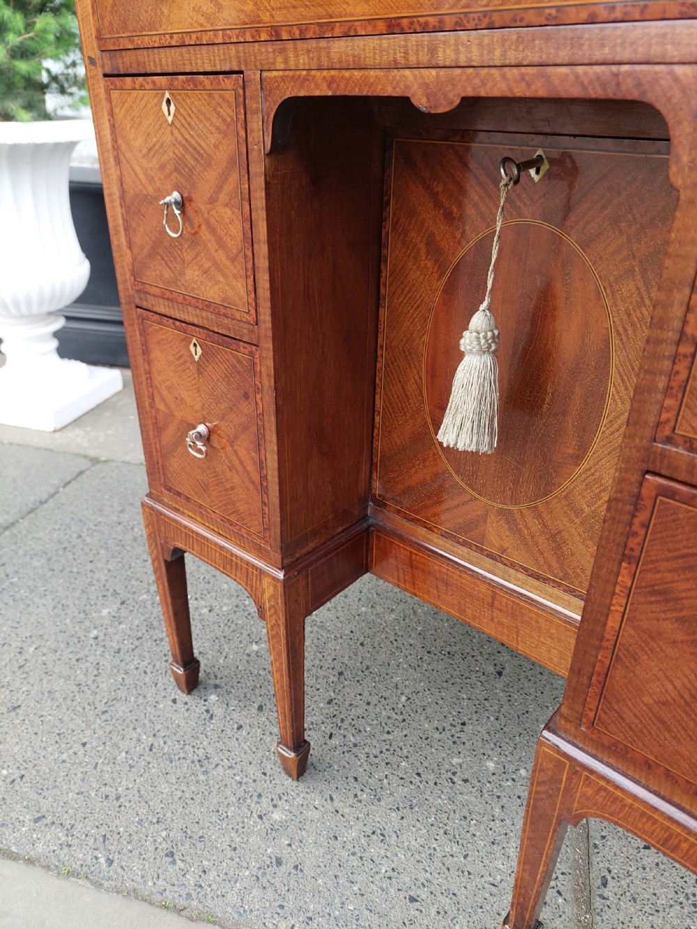 A late 19th-century George II style mahogany kneehole desk featuring herringbone inlay, brass drop handles, and a central recessed cupboard. View XI