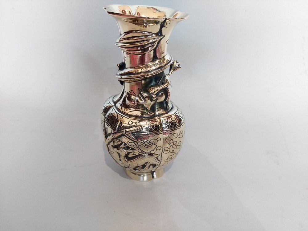 An early 20th-century Chinese brass vase featuring high-relief dragon and fauna ornamentation with a flared scalloped rim. View II
