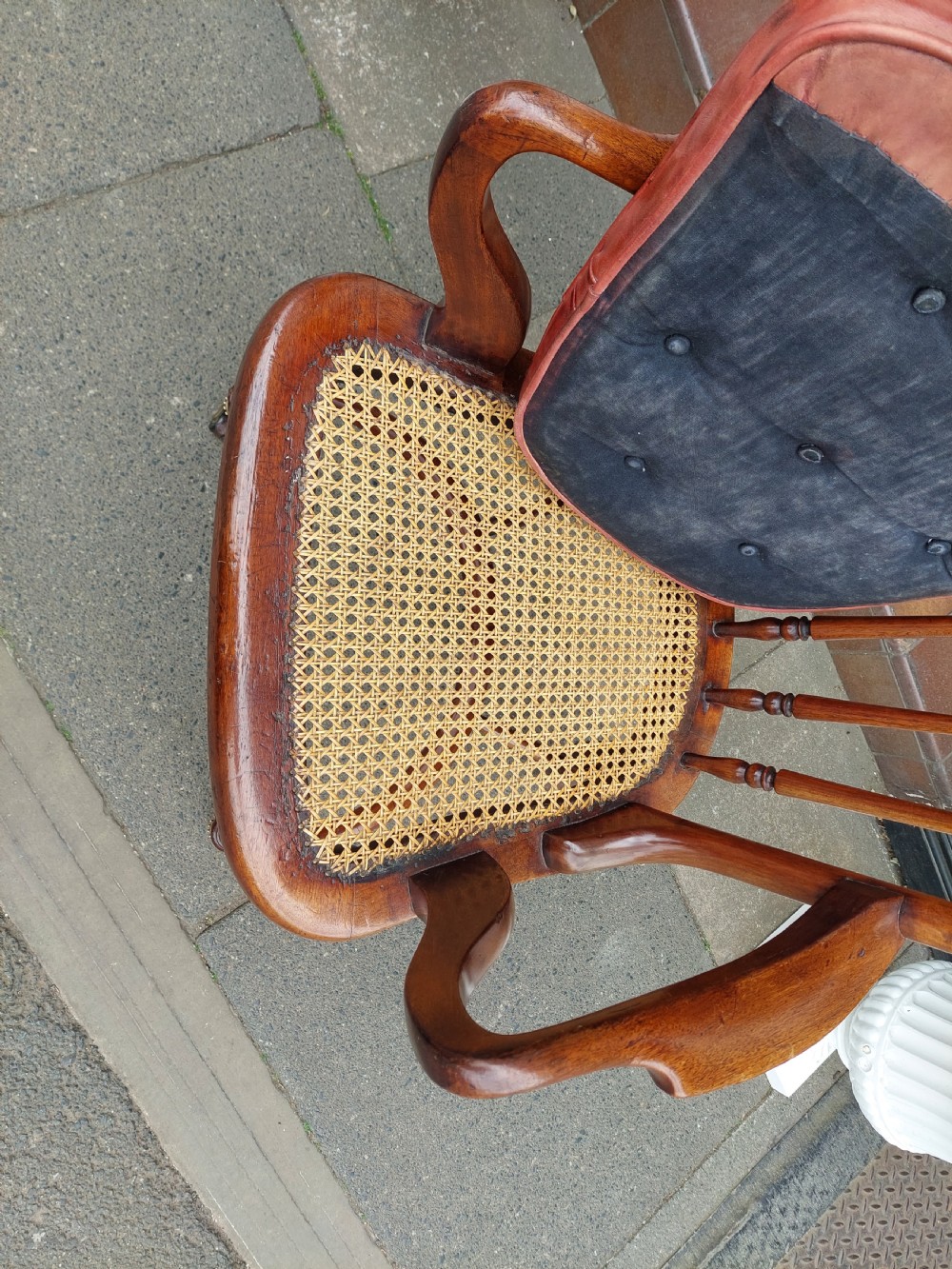 An early 19th-century mahogany desk chair featuring a spindle back, curved armrests, a red leather seat cushion, turned front legs, and brass castors. View VII