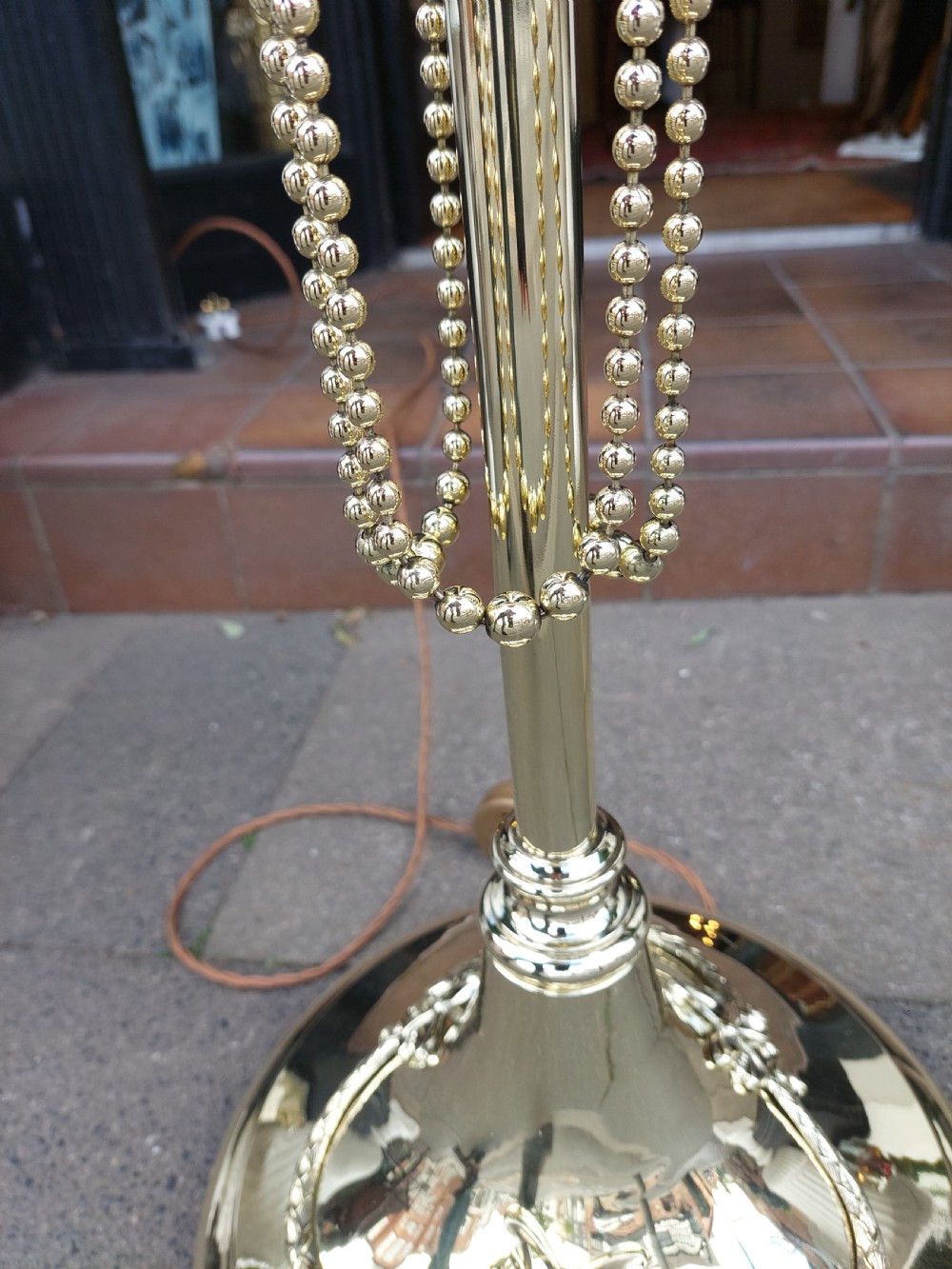 A late nineteenth-century brass standard floor lamp featuring a polished metal column with decorative swags and an ornate pink fabric shade with tassel fringe. View VII