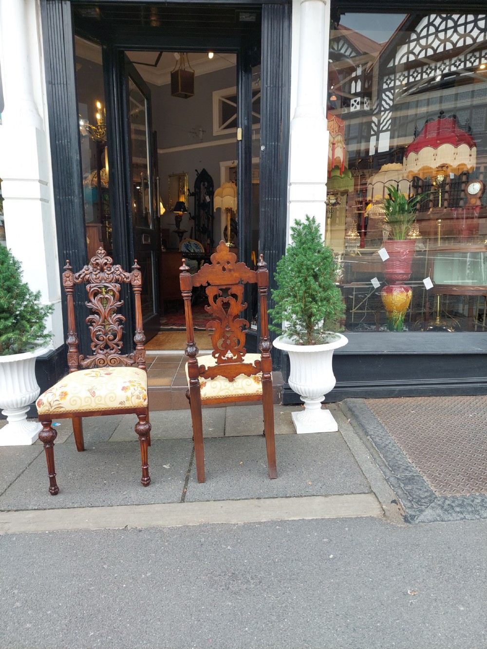 A pair of nineteenth-century carved walnut side chairs featuring openwork scrollwork backrests, turned legs, and cream floral pattern upholstery. View III
