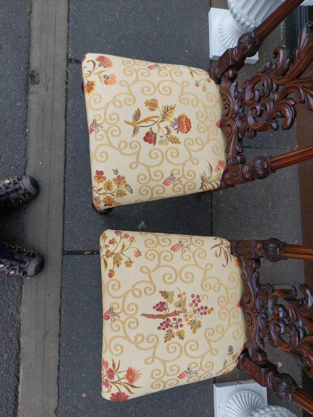 A pair of nineteenth-century carved walnut side chairs featuring openwork scrollwork backrests, turned legs, and cream floral pattern upholstery. View IV