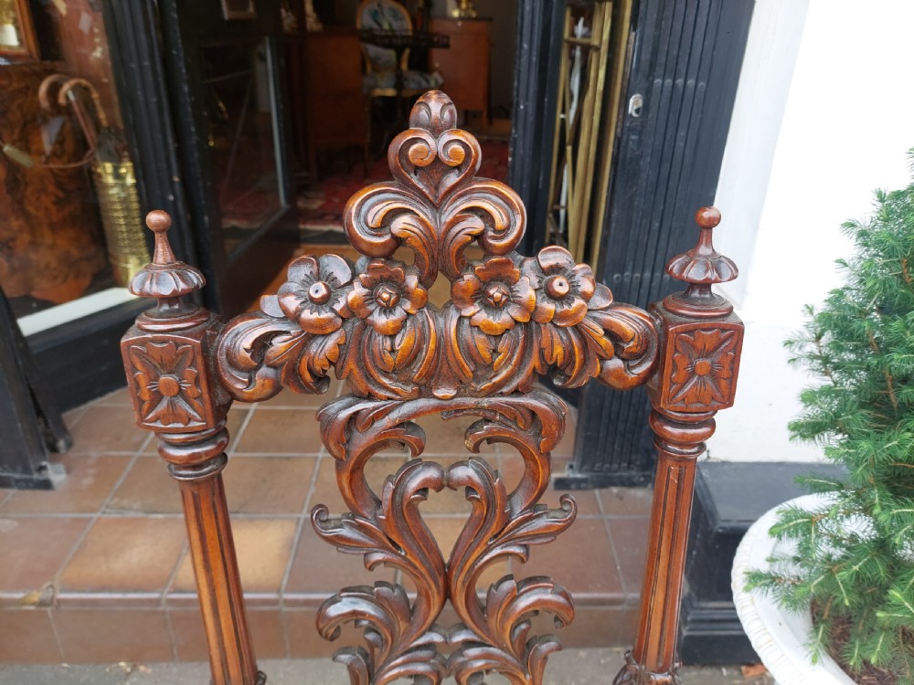 A pair of nineteenth-century carved walnut side chairs featuring openwork scrollwork backrests, turned legs, and cream floral pattern upholstery. View VI