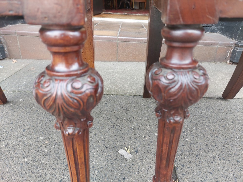 A pair of nineteenth-century carved walnut side chairs featuring openwork scrollwork backrests, turned legs, and cream floral pattern upholstery. View IX