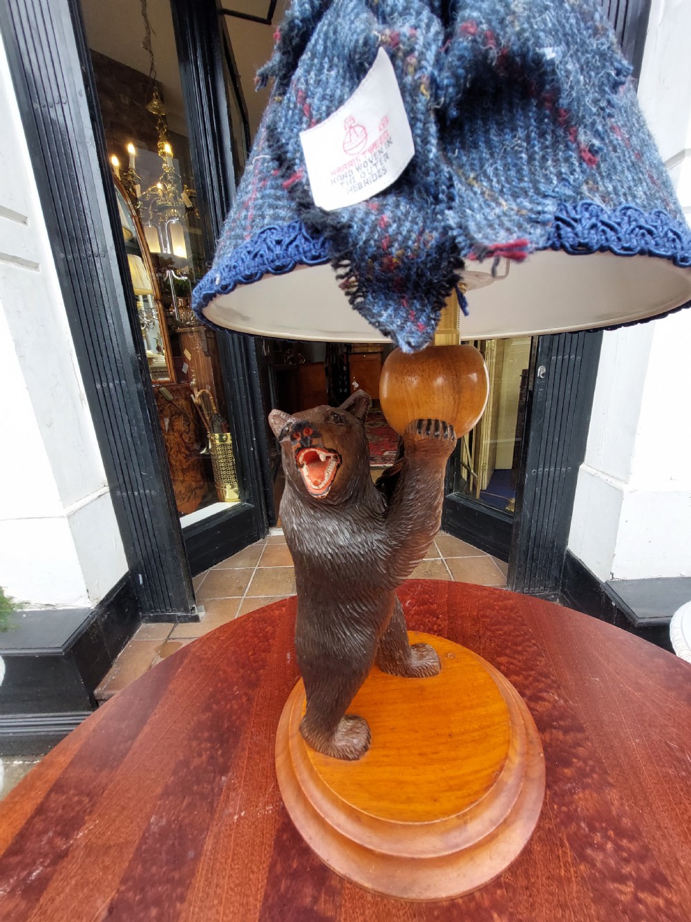 An early twentieth-century carved lindenwood Black Forest bear table lamp topped with a blue tartan fabric lampshade. View III