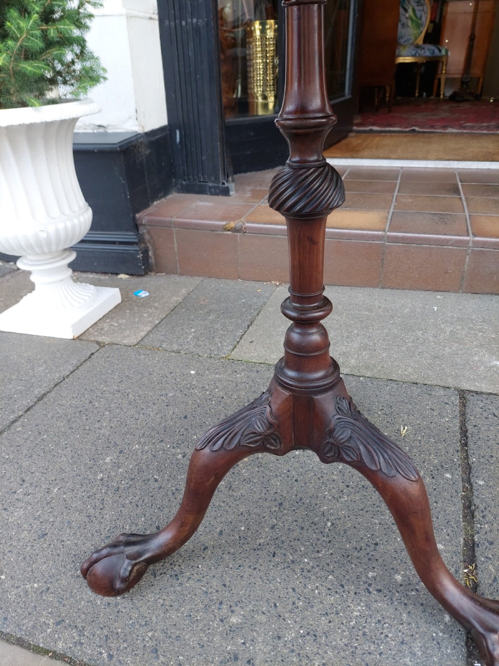 A George III mahogany snap top table featuring a rectangular top with a spindle gallery rim, set on a turned stem with carved tripod legs. View IX