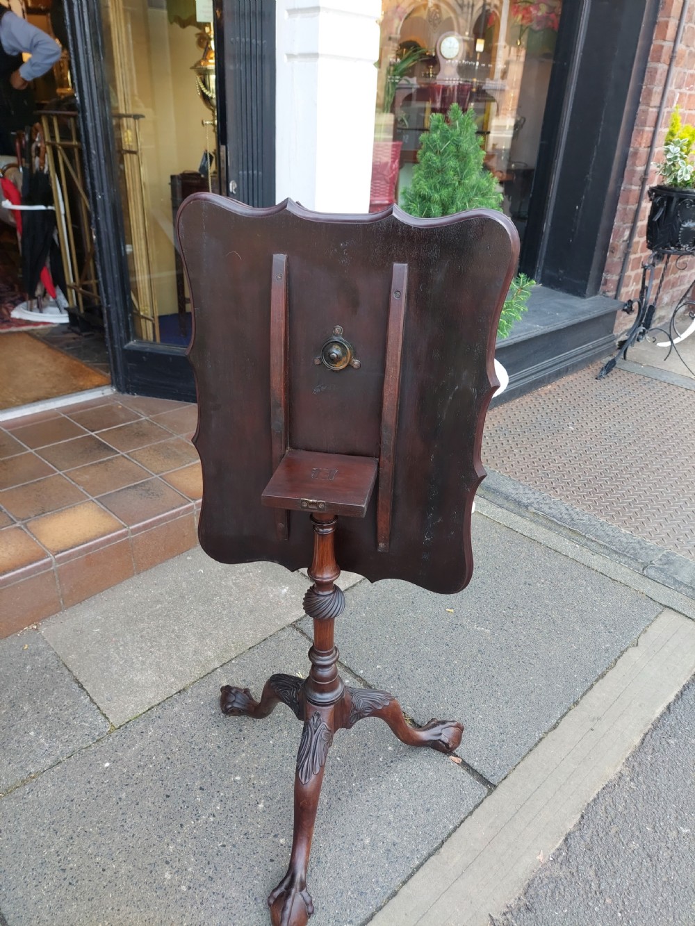 A George III mahogany snap top table featuring a rectangular top with a spindle gallery rim, set on a turned stem with carved tripod legs. View XIII