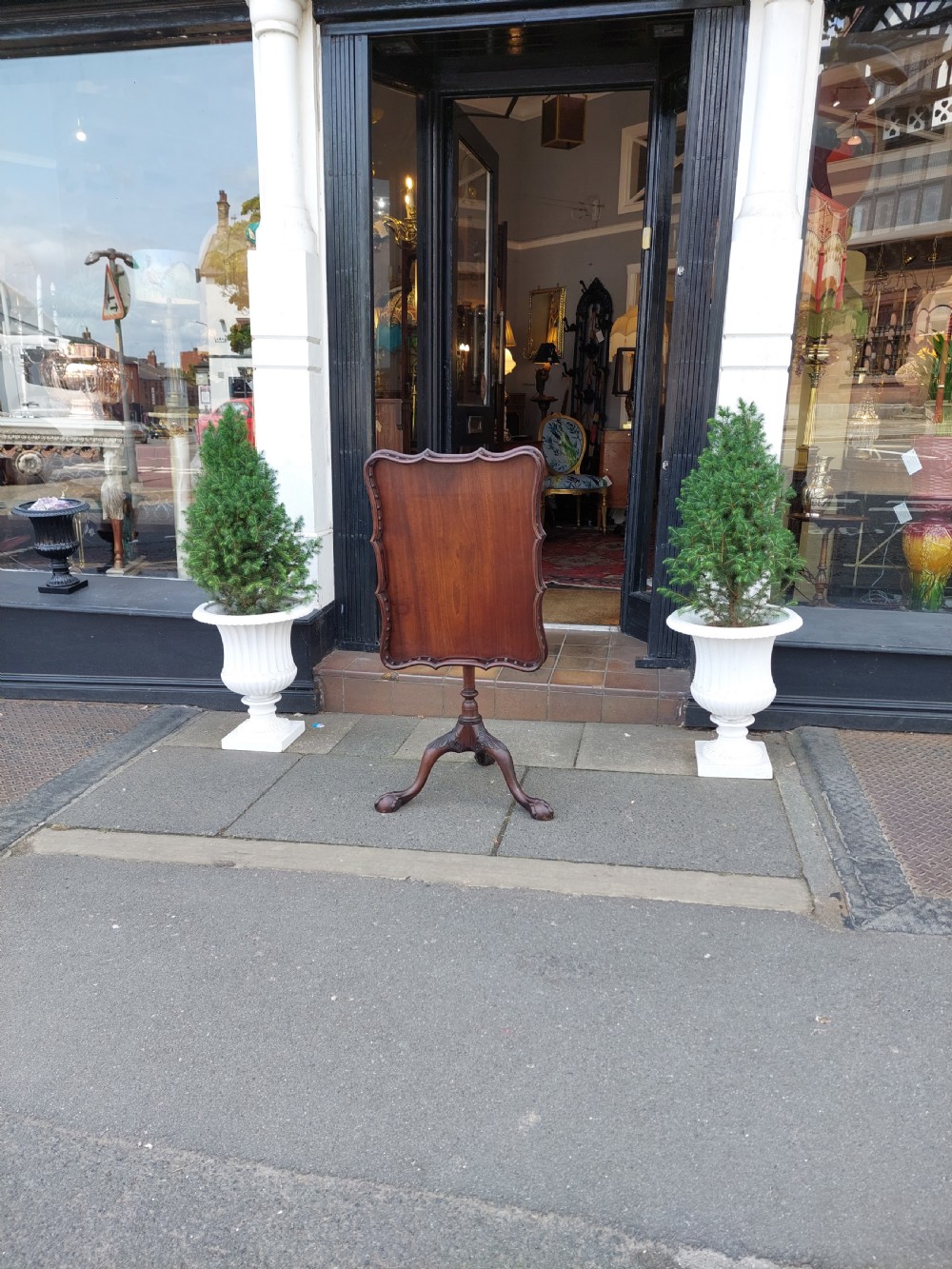 A George III mahogany snap top table featuring a rectangular top with a spindle gallery rim, set on a turned stem with carved tripod legs. View XIV