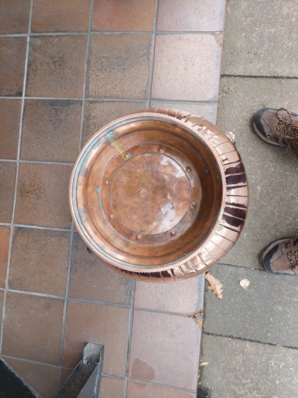 A bulbous Victorian polished copper vessel featuring embossed floral scrollwork, lower gadrooned fluting, two side loop handles, and a circular stepped pedestal base. View X