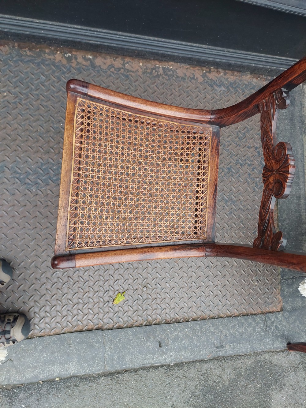 A set of six English Regency dining chairs featuring faux rosewood graining, brass inlay on the top rails, carved central splats, sabre front legs, and cream upholstered cushions. View VIII