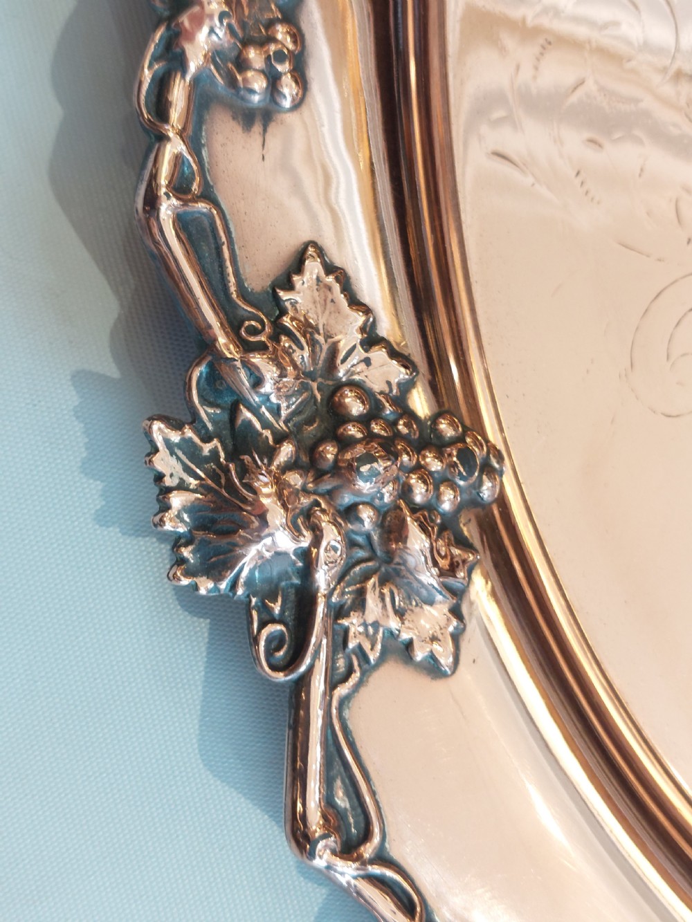A 19th-century oval copper serving tray featuring detailed scrollwork engraving on the surface, a relief grapevine border, and two cast handles. View III