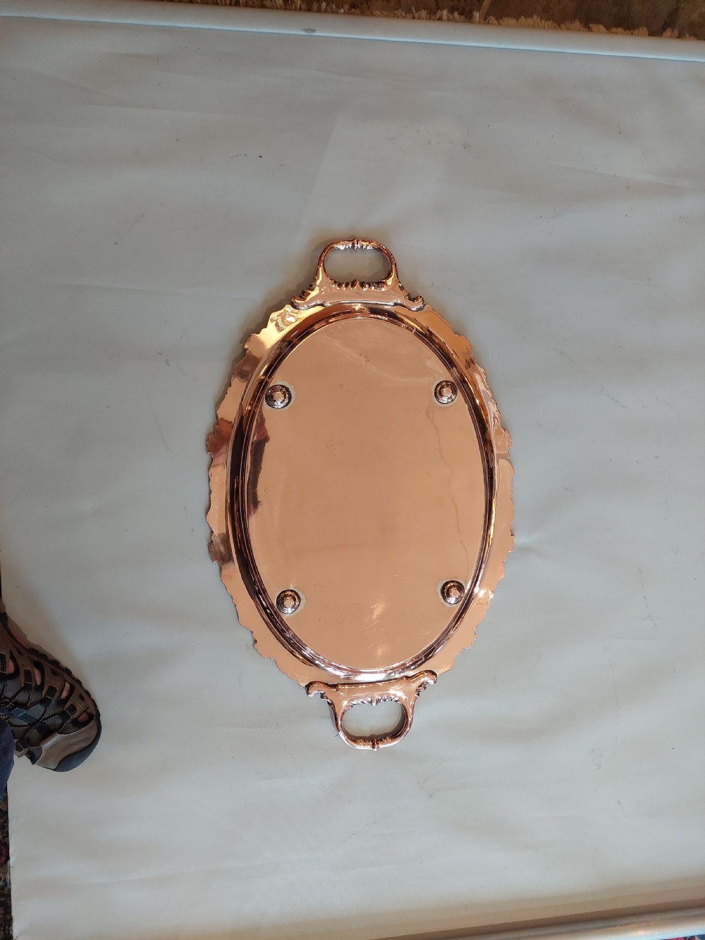A 19th-century oval copper serving tray featuring detailed scrollwork engraving on the surface, a relief grapevine border, and two cast handles. View VIII