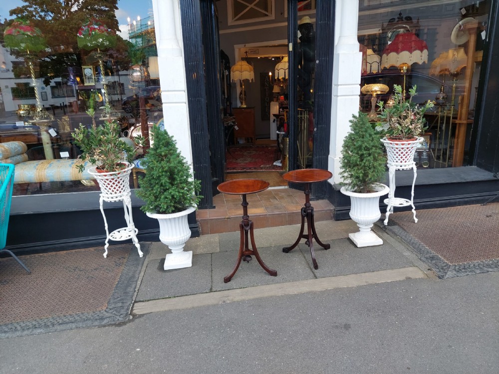 A pair of late Victorian mahogany occasional tables with circular tops, reeded columns, and carved tripod bases. View II