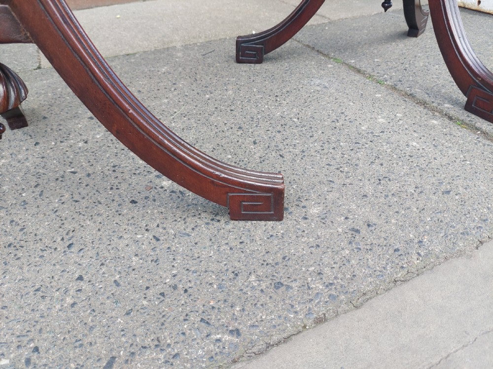 A pair of late Victorian mahogany occasional tables with circular tops, reeded columns, and carved tripod bases. View V