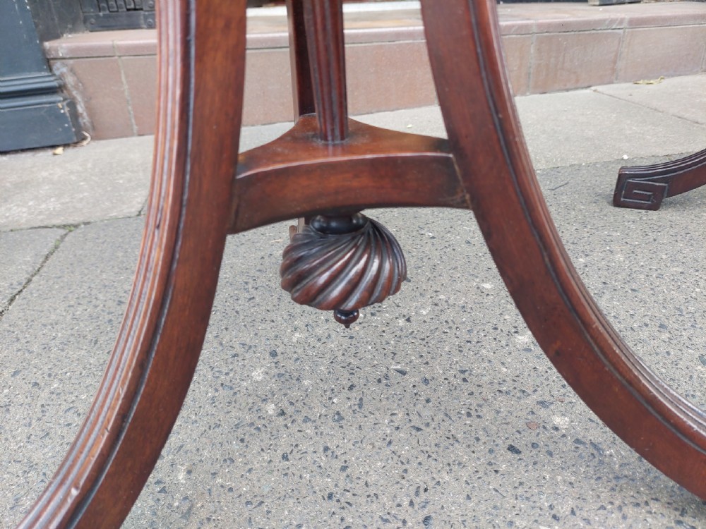 A pair of late Victorian mahogany occasional tables with circular tops, reeded columns, and carved tripod bases. View VI