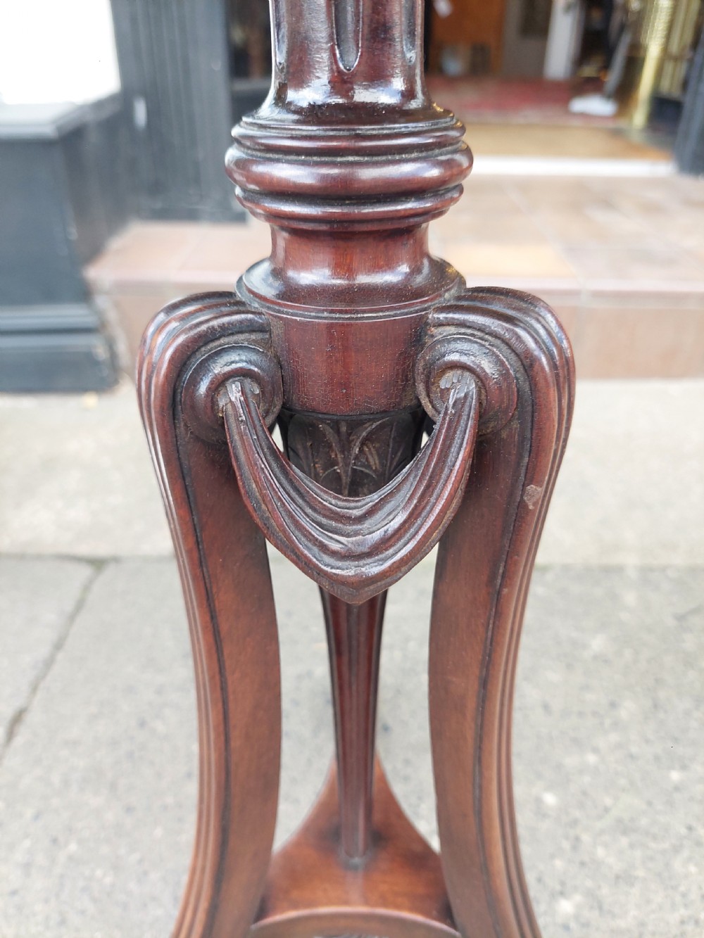 A pair of late Victorian mahogany occasional tables with circular tops, reeded columns, and carved tripod bases. View VII