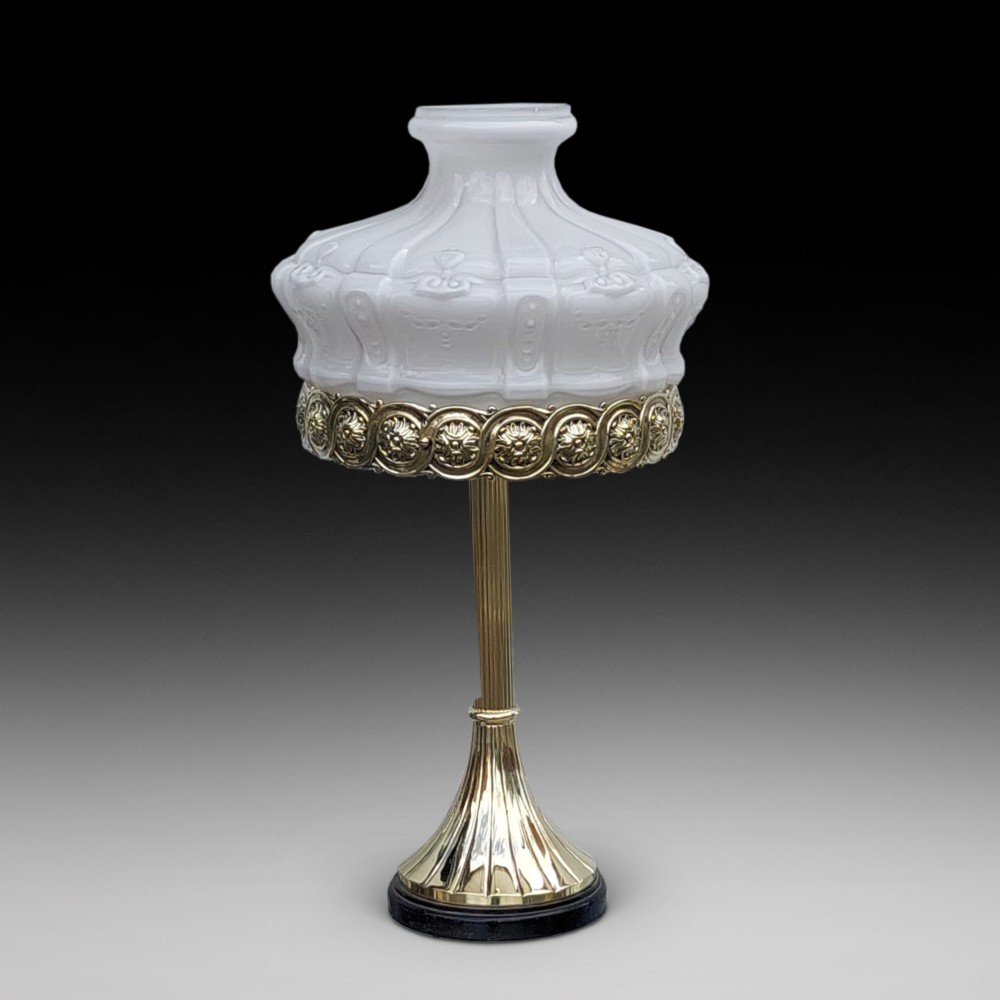 A late 19th-century Victorian brass table lamp featuring a fluted column, patterned brass rim gallery, and moulded white glass shade.