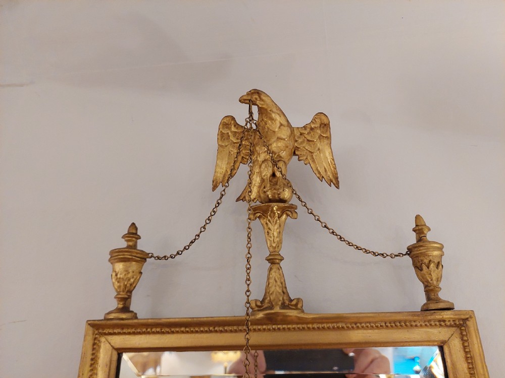 A tall rectangular George III giltwood pier mirror topped with a carved eagle cresting and decorative side urns. View III