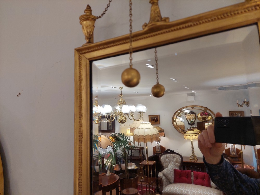 A tall rectangular George III giltwood pier mirror topped with a carved eagle cresting and decorative side urns. View IV