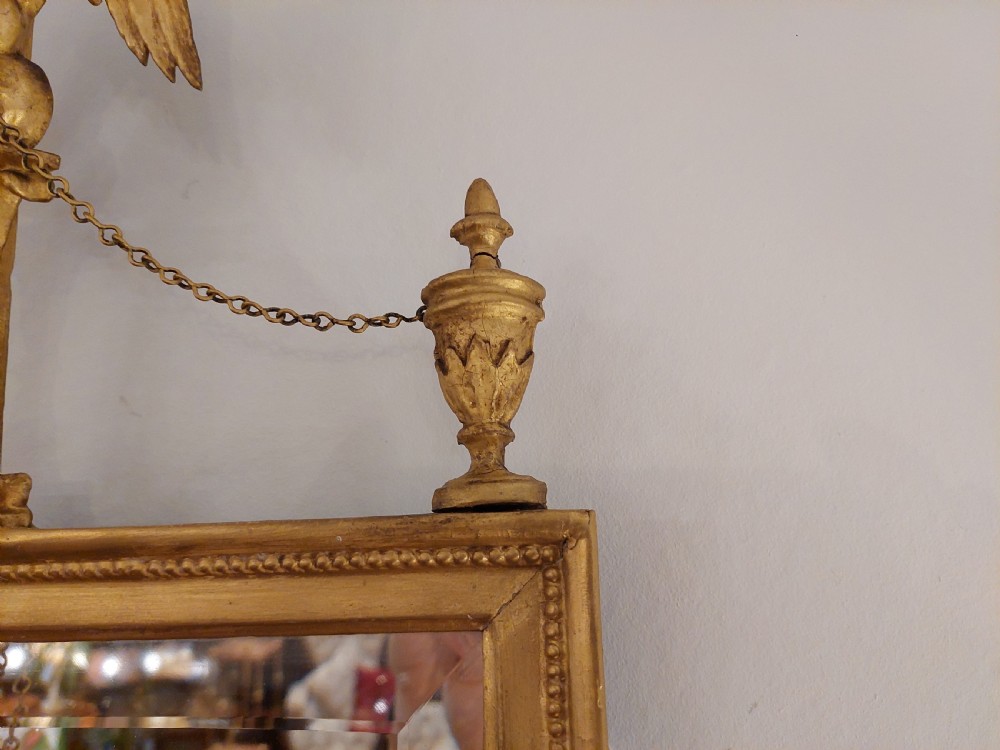 A tall rectangular George III giltwood pier mirror topped with a carved eagle cresting and decorative side urns. View V