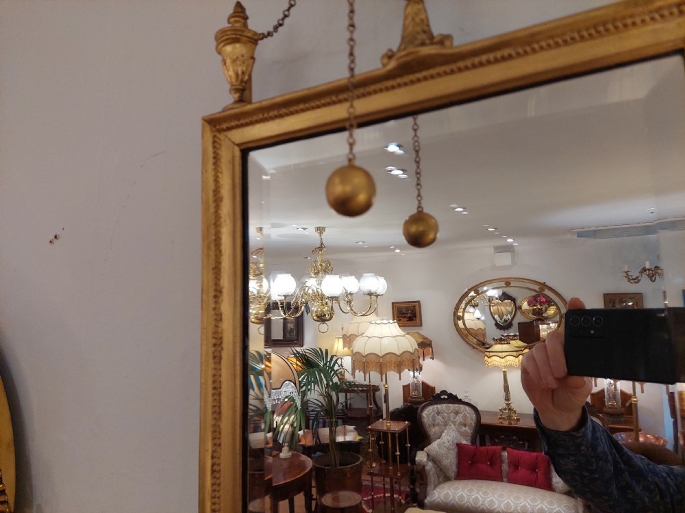 A tall rectangular George III giltwood pier mirror topped with a carved eagle cresting and decorative side urns. View VI