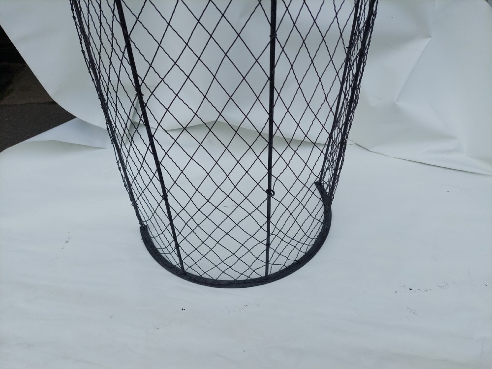 A tall, curved Victorian nursery fender constructed from black wire mesh with vertical iron supports and a polished brass top rail. View III