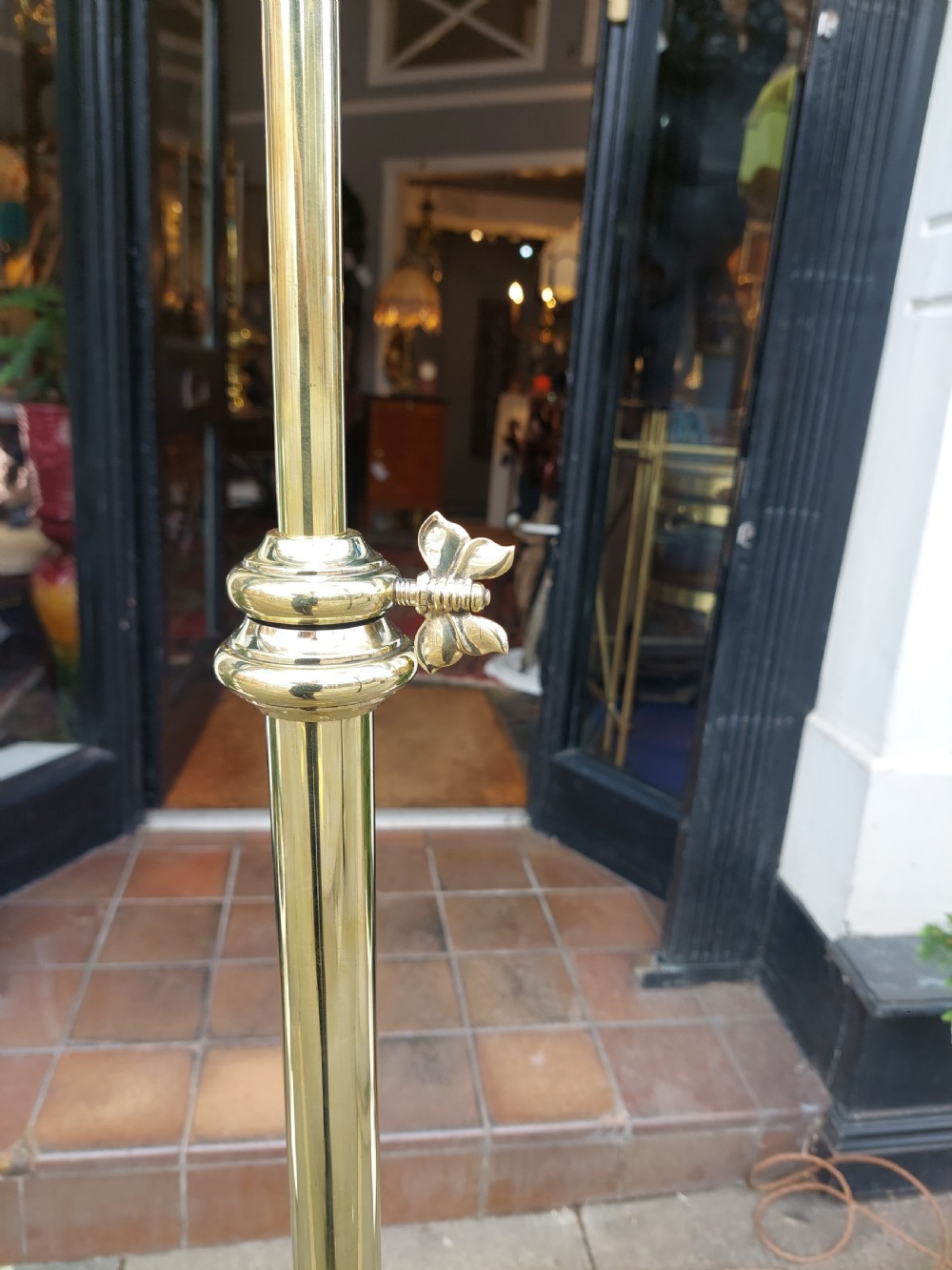 An early 20th-century Art Nouveau polished brass adjustable standard lamp featuring a tripod base with whiplash curves and three arms holding pink fluted glass shades. View VII
