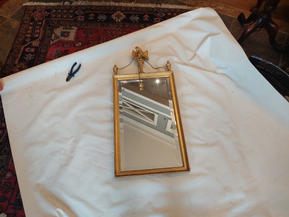 A tall rectangular George III giltwood pier mirror featuring an eagle surmounting a central crest with delicate hanging chains and flanking corner finials. View III