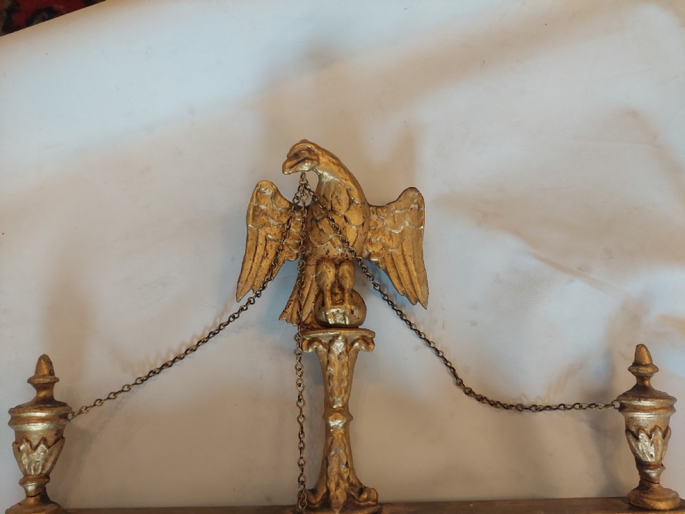 A tall rectangular George III giltwood pier mirror featuring an eagle surmounting a central crest with delicate hanging chains and flanking corner finials. View IV