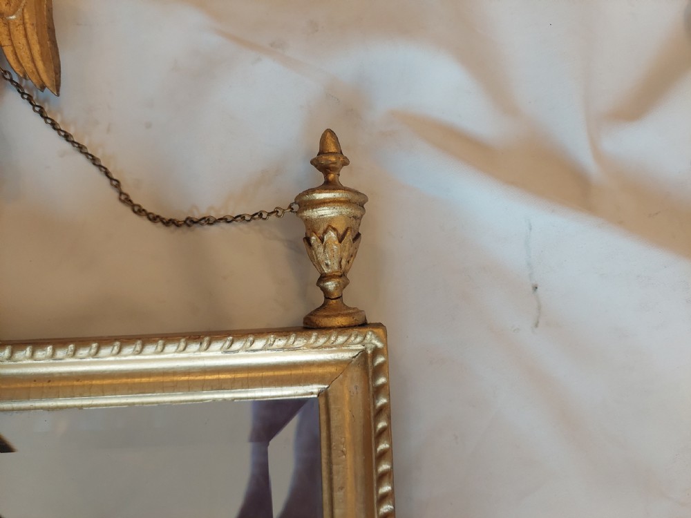A tall rectangular George III giltwood pier mirror featuring an eagle surmounting a central crest with delicate hanging chains and flanking corner finials. View V