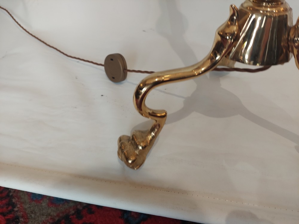 An Art Nouveau brass standard lamp with a slender central column, three curving arms holding frilled pink glass shades, and a tripod base. View XI