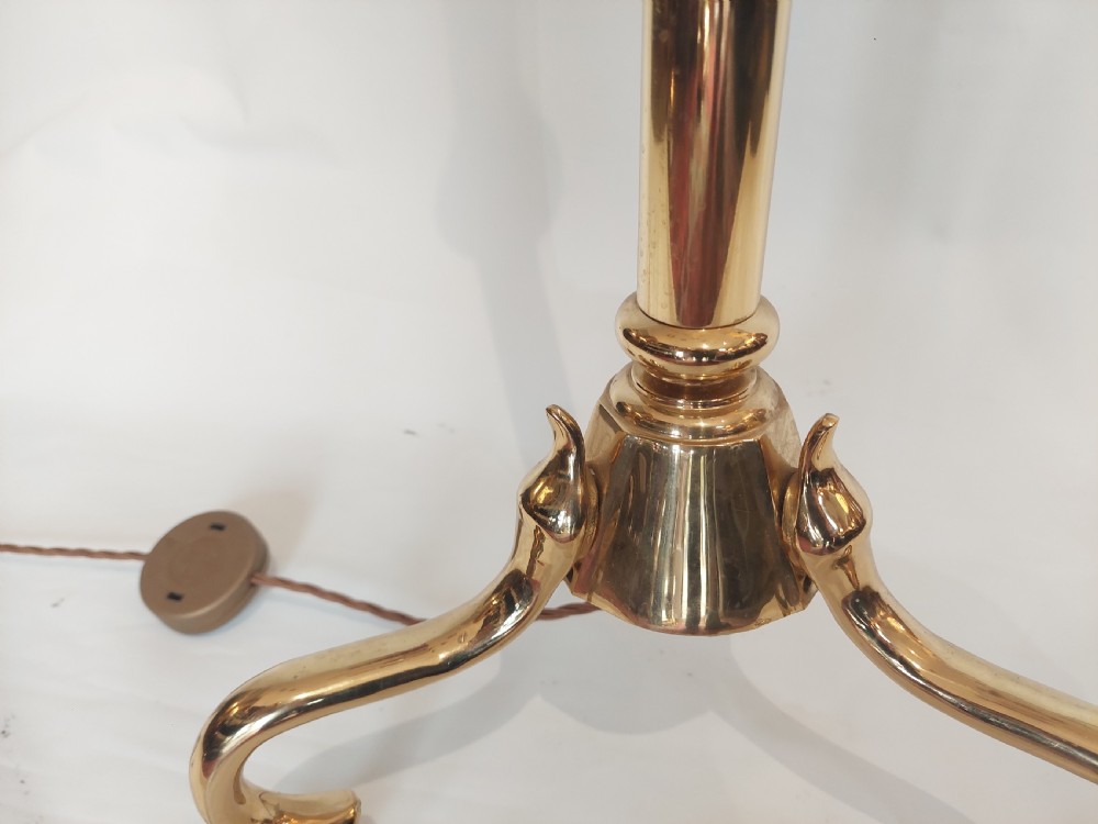 An Art Nouveau brass standard lamp with a slender central column, three curving arms holding frilled pink glass shades, and a tripod base. View XII