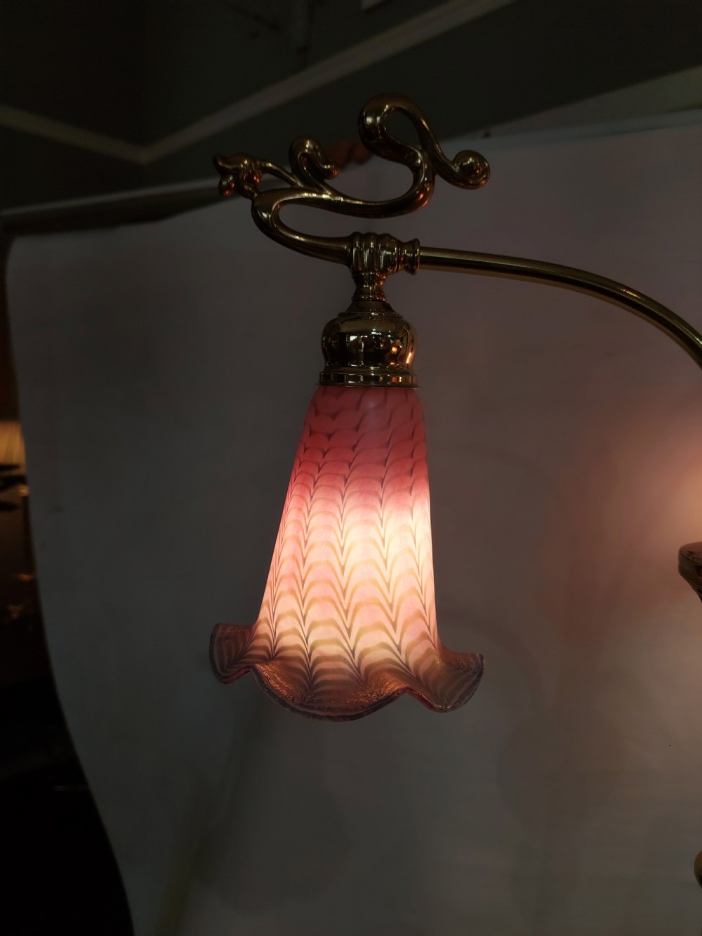 An Art Nouveau brass standard lamp with a slender central column, three curving arms holding frilled pink glass shades, and a tripod base. View XIII