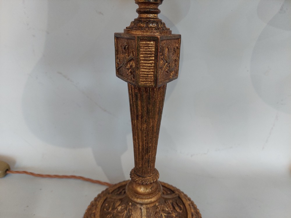 A pair of early 19th-century French giltwood candlestick table lamps with fluted columns, square relief blocks, circular beaded bases, and cream flared shades. View V