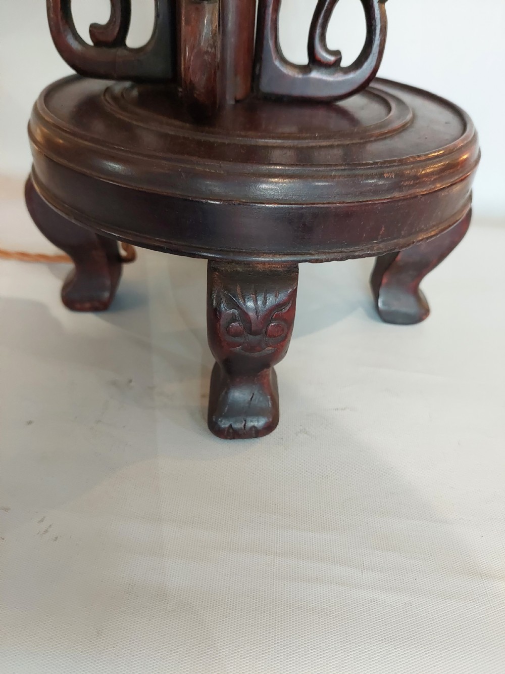 A late 19th-century dark carved hardwood lantern stand shaped like a dragon holding a suspended bamboo and paper cage lantern. View III