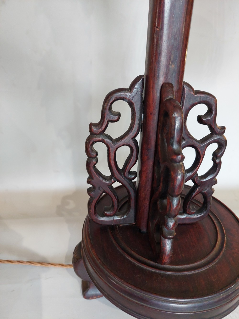 A late 19th-century dark carved hardwood lantern stand shaped like a dragon holding a suspended bamboo and paper cage lantern. View IV