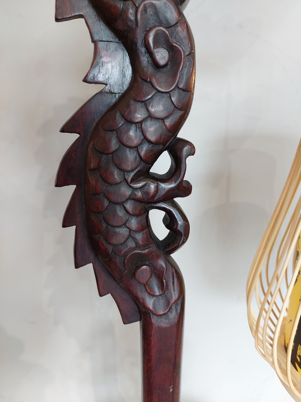 A late 19th-century dark carved hardwood lantern stand shaped like a dragon holding a suspended bamboo and paper cage lantern. View V