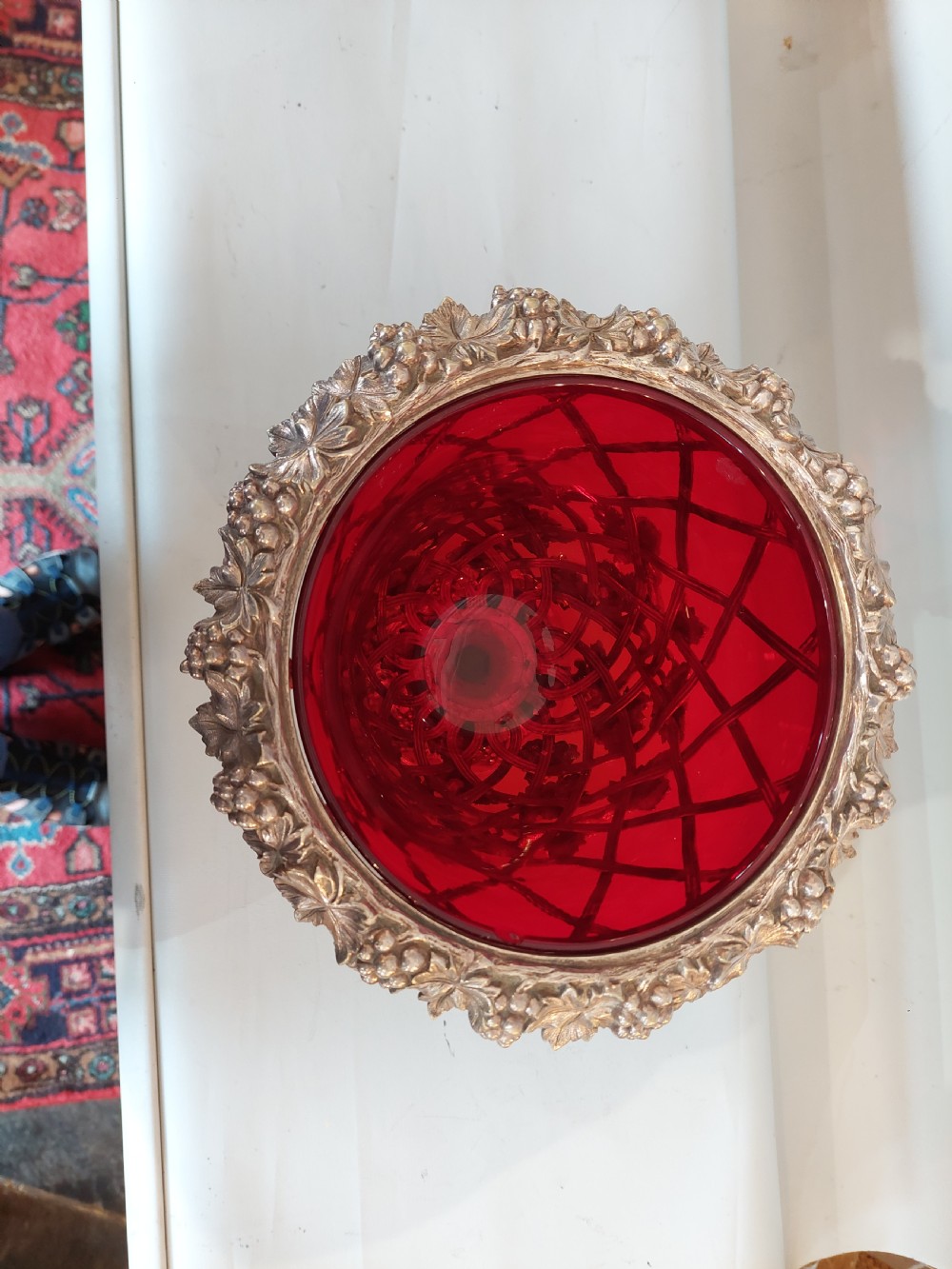 A late nineteenth-century cranberry glass wine cooler encased in an ornate silver-plated lattice frame with sculpted grapevine and leaf motifs. View II