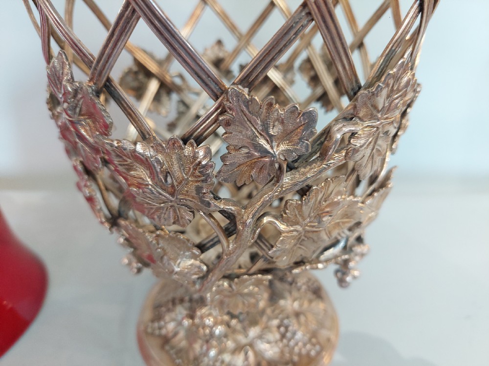 A late nineteenth-century cranberry glass wine cooler encased in an ornate silver-plated lattice frame with sculpted grapevine and leaf motifs. View V