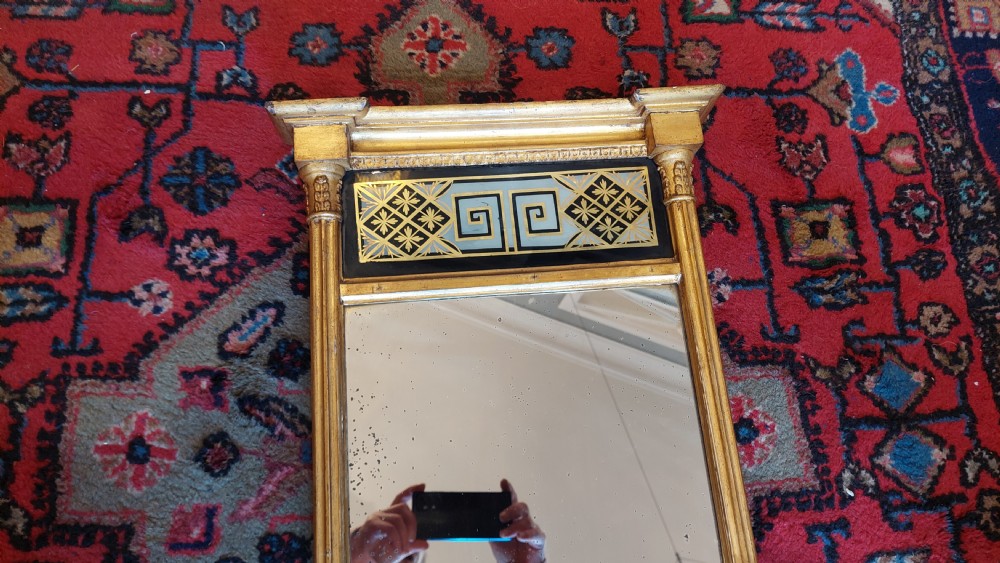 An upright rectangular Regency giltwood wall mirror featuring fluted pilasters and a frieze panel with Greek key detailing. View III