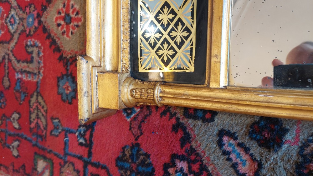 An upright rectangular Regency giltwood wall mirror featuring fluted pilasters and a frieze panel with Greek key detailing. View V
