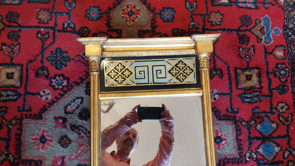 An upright rectangular Regency giltwood wall mirror featuring fluted pilasters and a frieze panel with Greek key detailing. View VI