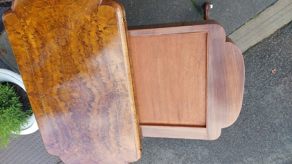 A nineteenth-century burr walnut games and work table featuring marquetry inlay, turned support columns, a lower work well, and carved legs on castors. View VII