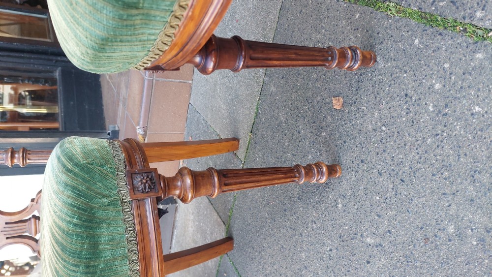 A pair of Victorian mahogany occasional chairs featuring fluted front legs and padded green velvet seats and backrests. View IV
