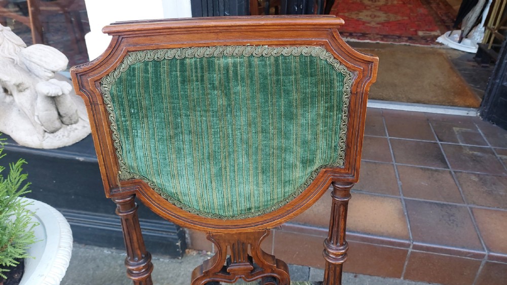A pair of Victorian mahogany occasional chairs featuring fluted front legs and padded green velvet seats and backrests. View V