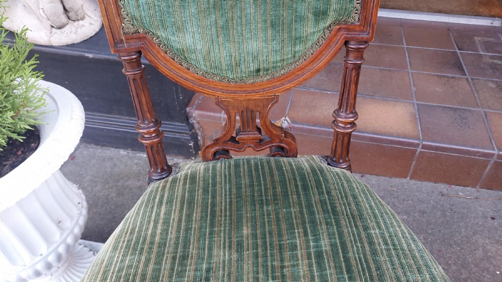 A pair of Victorian mahogany occasional chairs featuring fluted front legs and padded green velvet seats and backrests. View VI