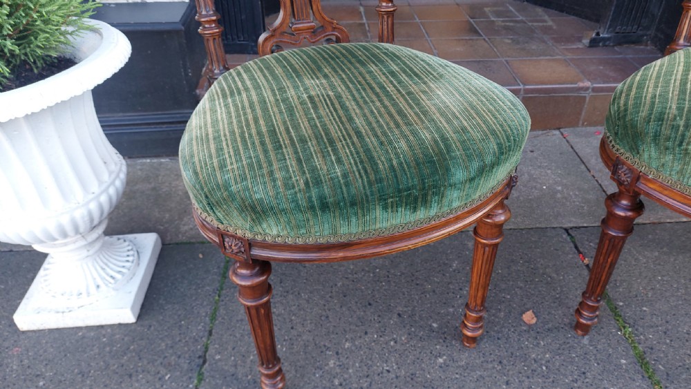 A pair of Victorian mahogany occasional chairs featuring fluted front legs and padded green velvet seats and backrests. View VII