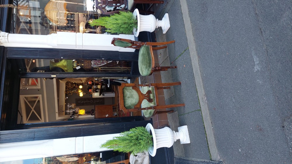 A pair of Victorian mahogany occasional chairs featuring fluted front legs and padded green velvet seats and backrests. View IX