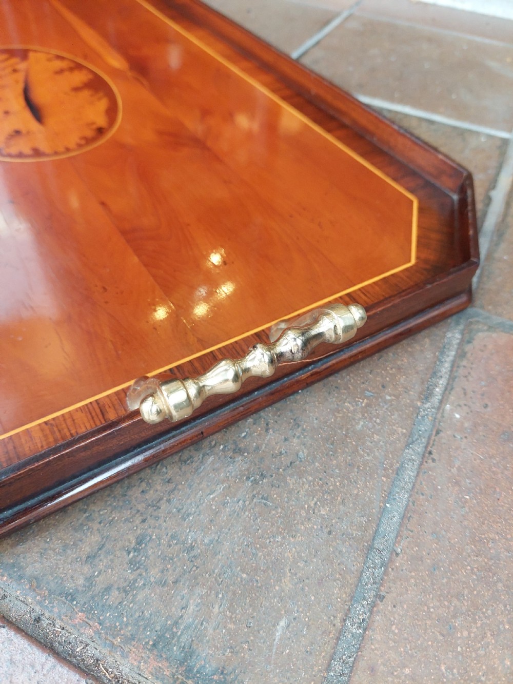 An octagonal wooden tray crafted from burr yew timber with rosewood crossbanding, featuring an oval central shell marquetry inlay and twin brass side handles. View II